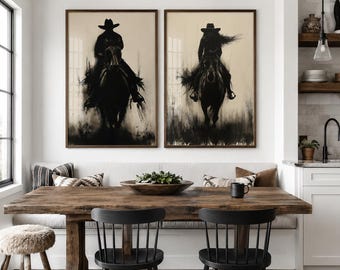 May include: Two framed vertical wall art prints featuring black silhouettes of a person riding a horse against a light beige background. The artwork depicts a rider in a cowboy hat on horseback, rendered in a dark, ink-wash style with blurred edges.