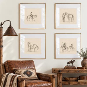 May include: Four square framed wall art prints featuring charcoal-style sketches of cowboys and Native Americans with horses. The prints are displayed in thin gold frames with white matting, arranged in a grid on a light-colored wall.