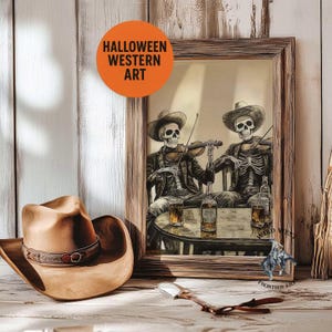 May include: A framed artwork with a Halloween Western theme. The image features two skeleton cowboys playing violins at a table with whiskey bottles and glasses. A brown cowboy hat and a decorative spoon are in the foreground. The artwork is labeled "Halloween Western Art."