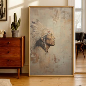 May include: A framed portrait of a Native American man in profile, wearing a feathered headdress. The artwork features a muted color palette with beige, brown, and cream tones. The painting has a vintage aesthetic, with visible brushstrokes and a textured appearance.