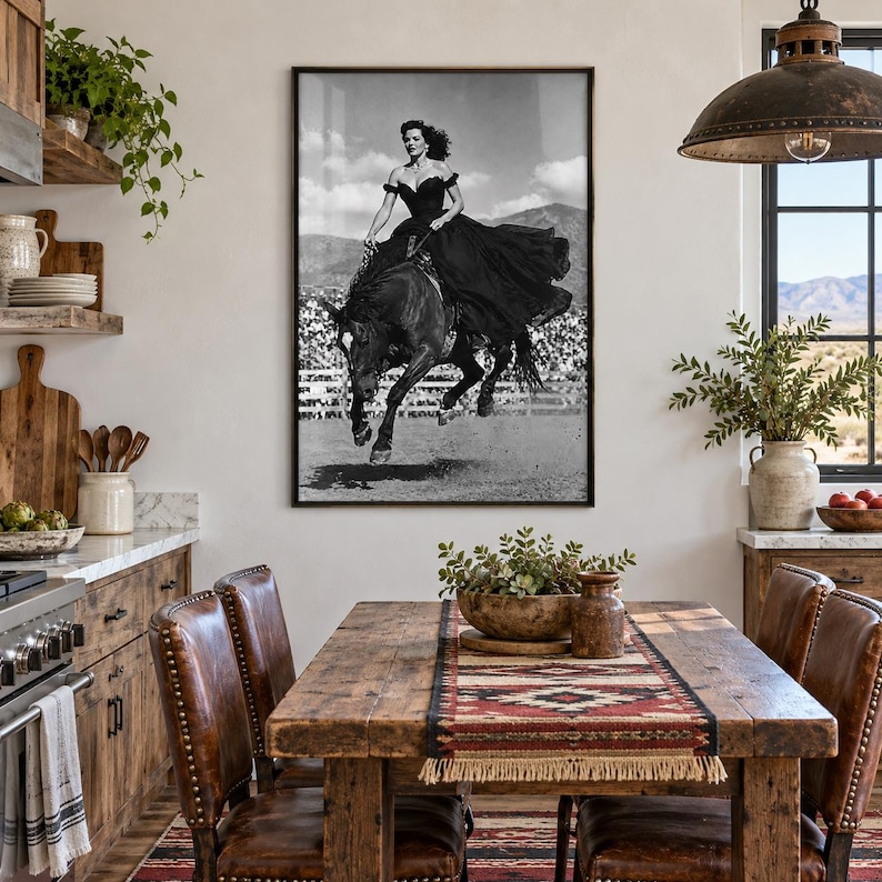 May include: A framed black and white wall art print depicting a person in a long dark gown riding a horse in mid-gallop. The scene is set in an outdoor arena with mountains in the background, capturing a dynamic moment of equestrian movement.
