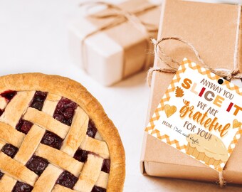 Könnte beinhalten: Ein gebackener Kirschkuchen mit Gitterkruste liegt neben einer Geschenkbox, die mit Bindfaden verschnürt ist. Die Geschenkbox hat ein Etikett mit der Aufschrift "Anyway you slice it, we are grateful for you!" in Orange und Braun.
