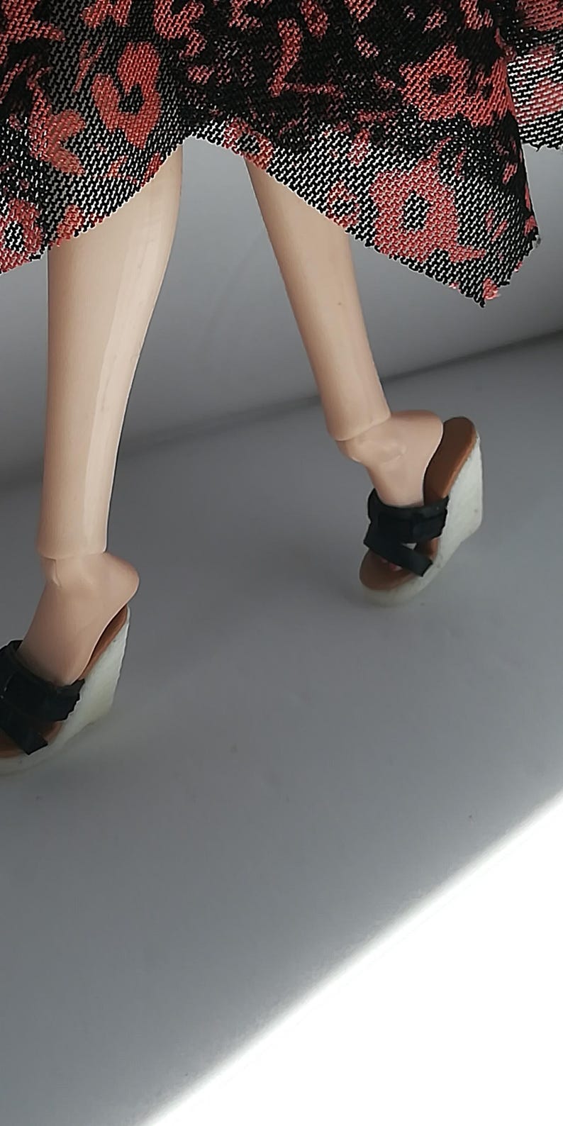 Op de afbeelding: Een paar zwarte wedgesandalen met een wit platform. De sandalen hebben meerdere banden over de voet en enkel.