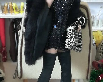 May include: A fashion doll wearing a black sequined dress with a black fur coat, black thigh-high boots, and a black and white polka dot handbag.