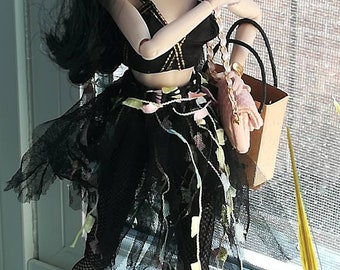 May include: A fashion doll wearing a black and white layered skirt, black fishnet stockings, and black heeled boots. The doll is holding a pink drink and a brown shopping bag with a pink purse inside.