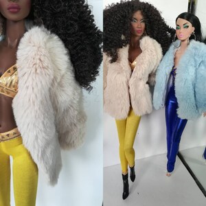 Puede incluir: Tres mu&ntilde;ecas de moda que llevan chaquetas de piel sint&eacute;tica. La mu&ntilde;eca de la izquierda lleva una chaqueta de piel sint&eacute;tica blanca, la mu&ntilde;eca del centro lleva una chaqueta de piel sint&eacute;tica crema y la mu&ntilde;eca de la derecha lleva una chaqueta de piel sint&eacute;tica azul claro.