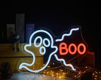 May include: White neon ghost with a red neon "BOO" sign. The ghost is outlined in white and has two large eyes and a mouth. The sign is outlined in white and has a wavy edge. The sign is 35 x 24 cm, 40 x 27 cm, or 50 x 34 cm.