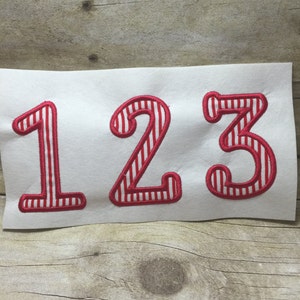 May include: Red and white striped numbers 1, 2, and 3 on a white background.