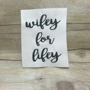 May include: White card with black cursive text that reads "wifey for lifey".
