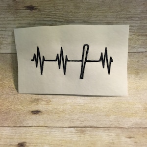 Puede incluir: Diseño bordado en blanco y negro de un latido del corazón con un bate de béisbol en el medio.