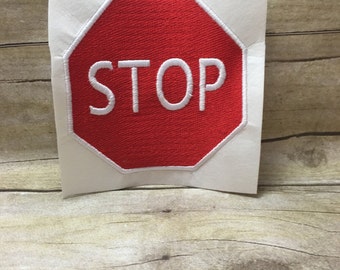 Könnte beinhalten: Ein rotes achteckiges Stoppschild mit weißen Buchstaben. Das Schild zeigt "STOP" in Großbuchstaben.
