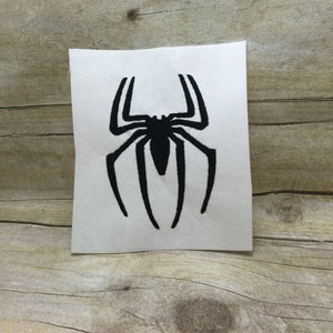 May include: Black embroidered iron-on patch of a spider with eight legs, a rounded body, and a web design.