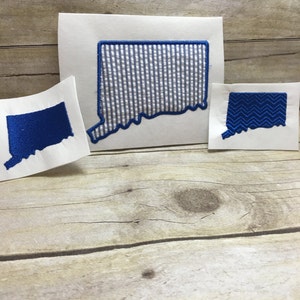 May include: Three different embroidered patches of the state of Connecticut. One patch is solid blue, one is blue and white striped, and one is blue with a chevron pattern.