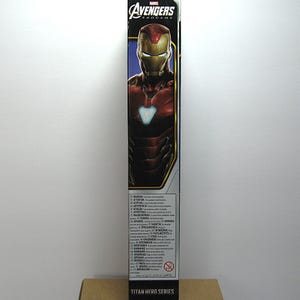 May include: A tall, rectangular box featuring Iron Man from Avengers: Endgame. The box has a blue and red color scheme with the Avengers logo at the top. The words "Titan Hero Series" are at the bottom.