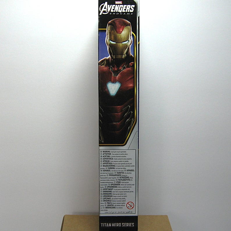 May include: A tall, rectangular box featuring Iron Man from Avengers: Endgame. The box has a blue and red color scheme with the Avengers logo at the top. The words "Titan Hero Series" are at the bottom.