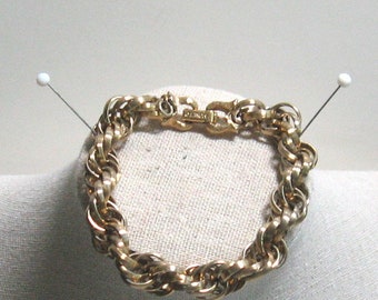 May include: A gold-toned twisted chain bracelet with a clasp.