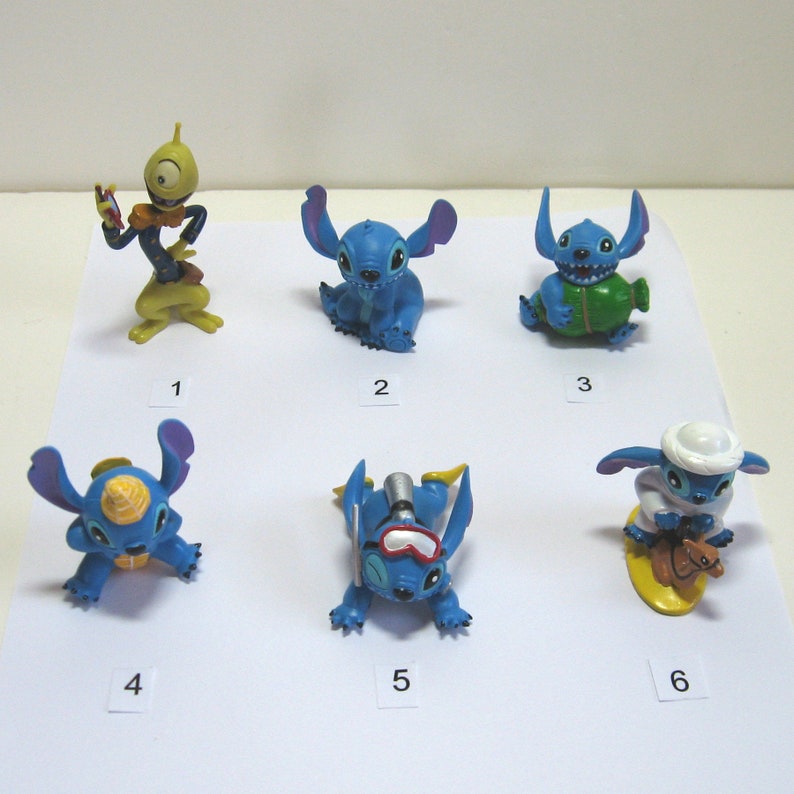K&ouml;nnte beinhalten: Eine Sammlung von sechs kleinen, farbenfrohen Stitch-Figuren. Die Figuren sind in verschiedenen Posen und Outfits, darunter Tauchausr&uuml;stung und ein Fez. Die Figuren sind haupts&auml;chlich blau mit Akzenten in Gelb, Gr&uuml;n und Wei&szlig;. Die Figuren sind von 1 bis 6 nummeriert.