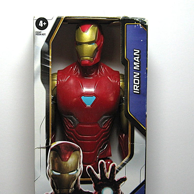 May include: A red and gold Iron Man action figure in its original packaging. The figure has a detailed design, with a red body, gold accents, and a blue chest emblem. The packaging features the words "Iron Man" and the age range "4+".