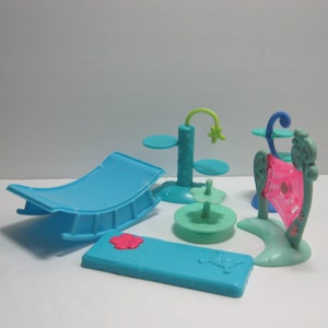 May include: A set of five blue plastic pet play structures for small animals. The set includes a hammock, a spinning platform, a tall platform with two levels, a small platform with a flower, and a web-shaped structure.