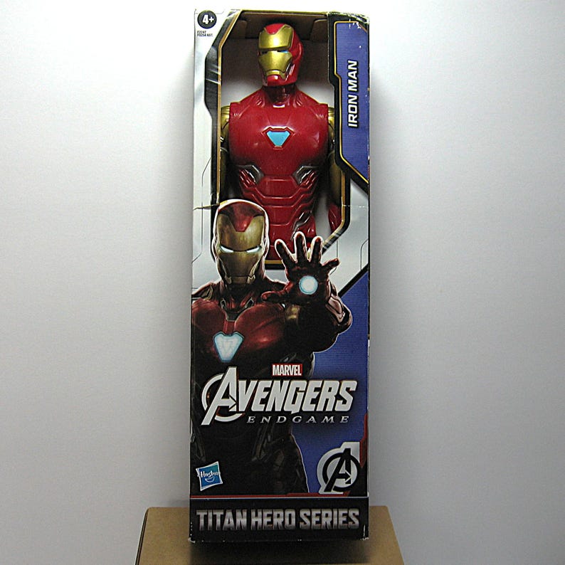 May include: Iron Man action figure in a box. The figure is red and gold, with a detailed design. The box features the Marvel Avengers Endgame logo and the words "Titan Hero Series". The figure is approximately 12 inches tall.