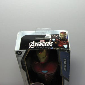 May include: A Marvel Avengers Endgame Iron Man action figure in its original packaging. The box features the Avengers logo and an image of Iron Man. The figure is recommended for ages 4 and up.