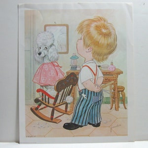 May include: A white poodle wearing a pink dress sits in a rocking chair while a young boy with blonde hair stands behind it holding a pair of scissors. The boy is wearing a white shirt, blue and white striped pants, and red suspenders.