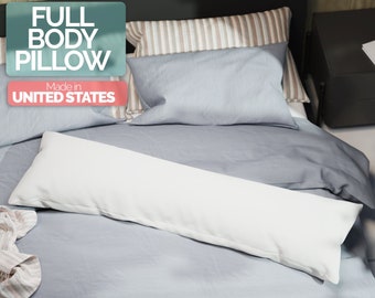 May include: A white full body pillow on a light blue bed with a striped pillow and a gray headboard. The pillow is made in the United States.
