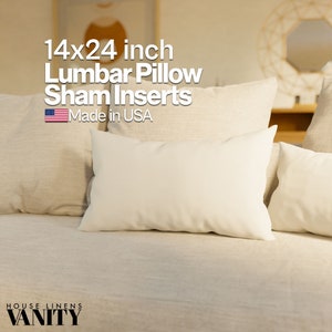 May include: A set of three white lumbar pillow inserts, measuring 14x24 inches. The pillows are made in the USA and are shown on a beige couch.