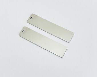 May include: Two silver rectangular metal tags with a hole at the top. The tags are blank and ready for personalization.