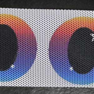 May include: Two eye-shaped decals with a rainbow gradient of colors, including red, orange, yellow, and blue. Each eye has a black pupil with a white star-shaped highlight. The decals are on a white, perforated background.