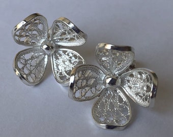 May include: A pair of silver filigree earrings shaped like four-leaf clovers.