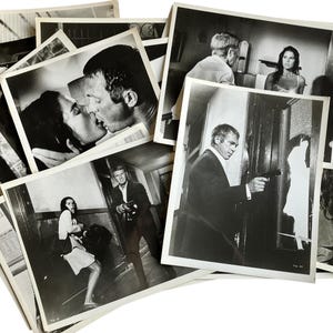 以下が含まれることがあります： 男性が銃を構えているシーン、キスをしているカップル、その他のドラマチックな瞬間など、さまざまなシーンを写した白黒の映画スチールのコレクション。画像はさまざまなサイズで、山のように配置されています。