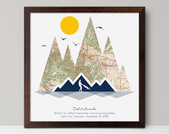 May include: A framed print with a map of mountains in a blue, gray, and yellow color scheme. The text "Dad & Amanda" is at the bottom of the print, along with the text "All that I am, all that I hope to be, I owe to my loving father Cañon City, Colorado September 25, 2000".