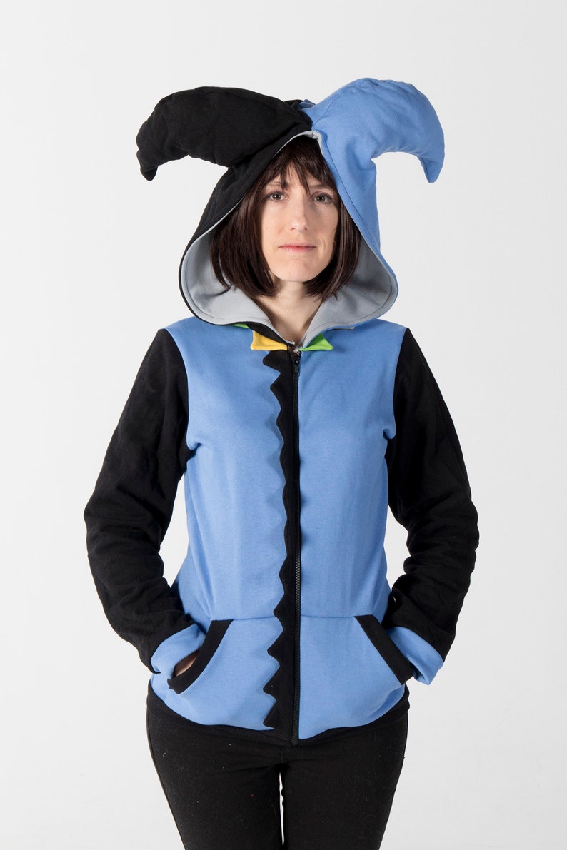 May include: A blue and black hooded sweatshirt with a jester-style hood. The sweatshirt has a zipper closure, black sleeves, and a light blue body with a jagged black trim. The hood is black and blue.