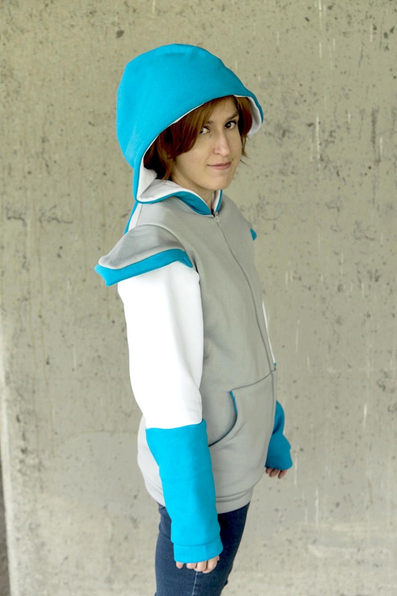 May include: A gray and white hoodie with a turquoise blue hood and sleeves. The hoodie has a zipper closure and a pocket on the front.