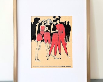 May include: A framed vintage advertisement print featuring a group of figures in red and black clothing on a cream background. The text at the bottom reads: par audation naturelle avec les vêtements enseignants L'belle Parisienne. The frame is gold.
