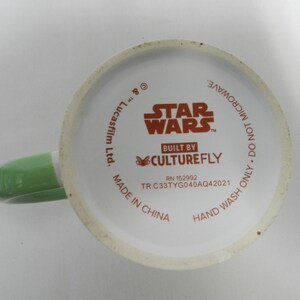 Op de afbeelding: Witte keramische mok met een groene handgreep. De bodem van de mok toont het Star Wars-logo en de tekst "BUILT BY CULTUREFLY". Extra tekst is "ALLEEN HANDWAS. NIET IN DE MAGNETRON."