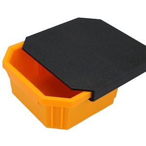 Könnte beinhalten: Ein gelber sechseckiger Aufbewahrungsbehälter mit einem schwarzen Deckel. Der Deckel ist geöffnet und der Behälter ist leer.