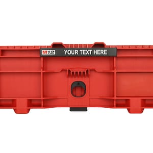 Puede incluir: Una caja de almacenamiento de plástico rojo brillante con un área de etiqueta negra rectangular en la parte superior central con el texto blanco M12 y el texto YOUR TEXT HERE. La caja tiene una estructura rígida moldeada con una abertura.