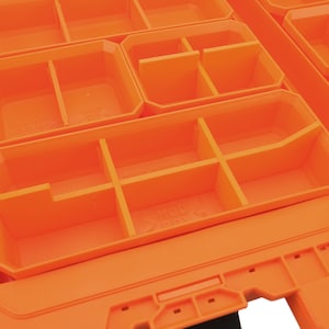 May include: Orange plastic storage box with multiple compartments. The box has a label that reads "X-Track".