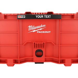 May include: Red Milwaukee PACKOUT storage box with the text "YOUR TEXT" above the logo. The box has a grid-like design and a black handle. The M18 logo is visible on the top left.