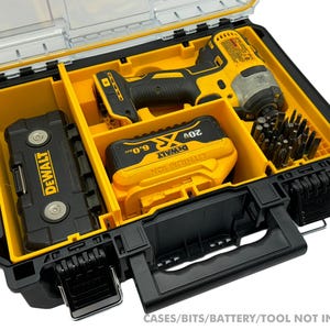 May include: An open black and yellow plastic tool case with a clear lid. The case has compartments for a drill, battery, and bits. The case is labeled "DEWALT" and "20V 6.0Ah".