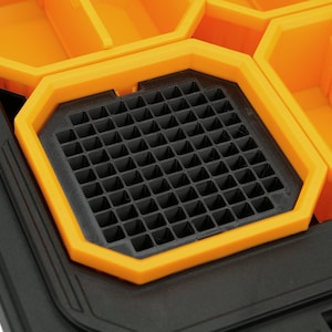 May include: Close-up of a black and orange tool organiser with a gridded compartment. The compartment is designed to hold small items like screws or nails.