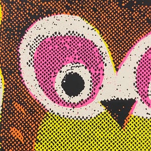 May include: Close-up of a pop art style illustration featuring a stylized owl. The owl's eyes are pink with black pupils, set against a white background. The owl's body is yellow with orange and black details.