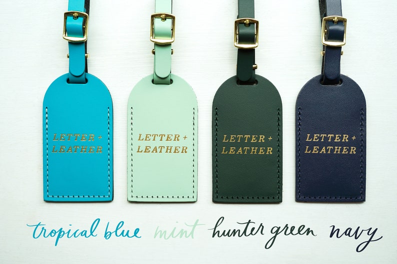 May include: Four leather luggage tags in different colors: tropical blue, mint, hunter green, and navy. Each tag has the text "LETTER + LEATHER" embossed in gold.