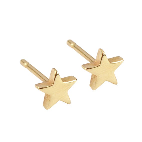 Premium Photo | A pair of gold star earrings with a star on the bottom