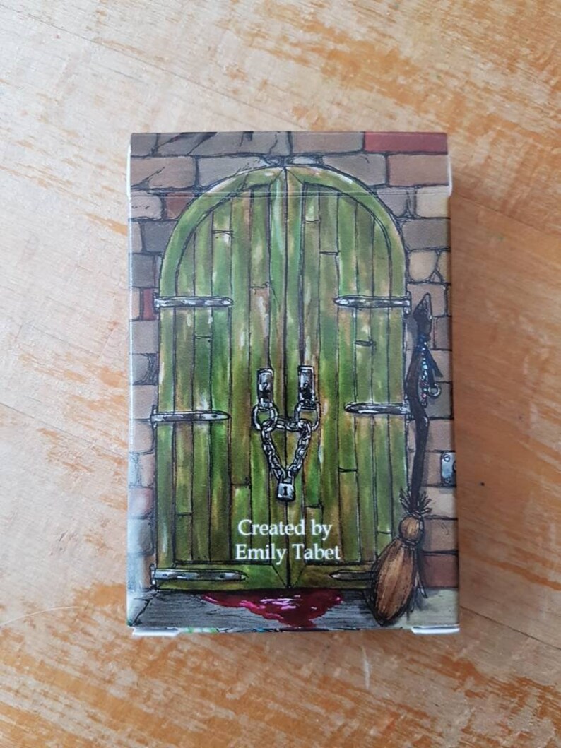 May include: A green wooden door with a chain and lock, a brick wall, and a broom leaning against the door. The text "Created by Emily Tabet" is printed below the door.