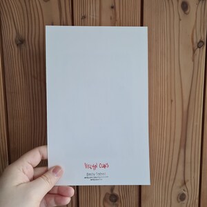 May include: White card with red text that reads "VILLAIN CLANS" and "Emily Tabat" with an email address and website address.