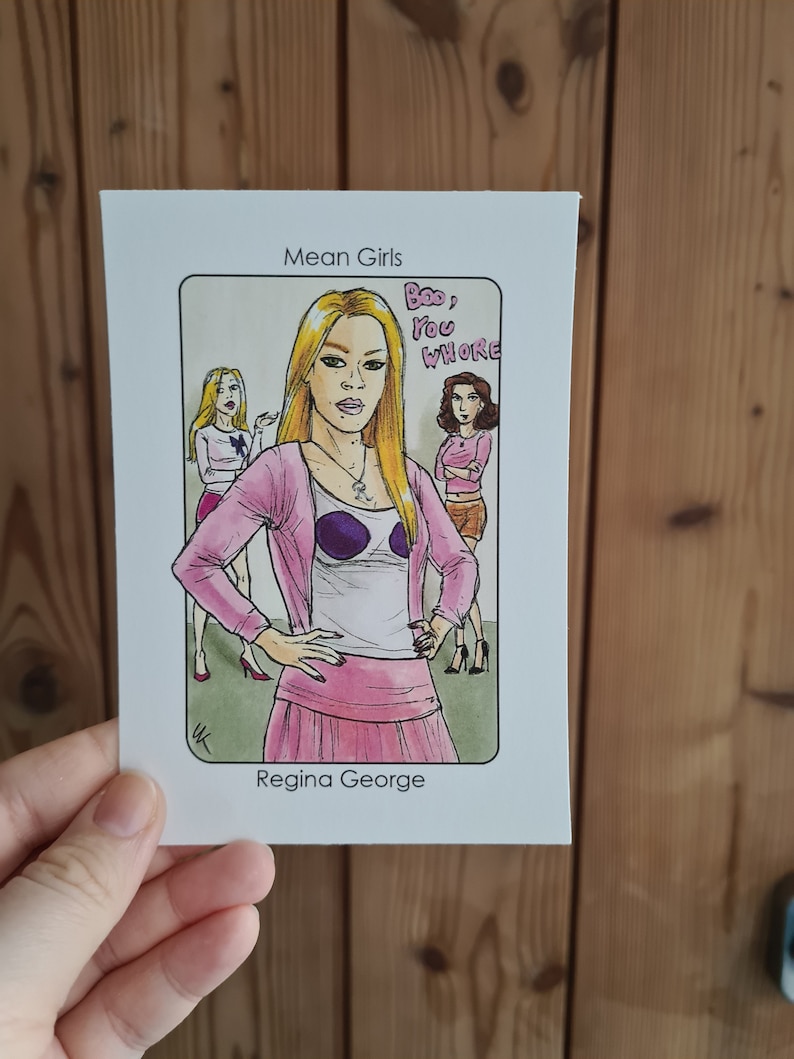 Puede incluir: Ilustraci&oacute;n dibujada a mano de Regina George de la pel&iacute;cula "Mean Girls". La imagen presenta a Regina con un atuendo rosa con el texto "Boo, You Whore". Las palabras "Mean Girls" y "Regina George" tambi&eacute;n son visibles.