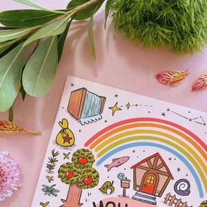 Może przedstawiać: Kolorowa ilustracja przedstawiająca tęczę, drzewo z czerwonymi jabłkami, dom i wodospad. Grafika ma fantazyjny styl z r&oacute;żowym tłem i elementami dekoracyjnymi, takimi jak gwiazdy i konstelacja.